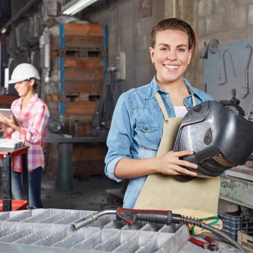 Junge Frau als Metallarbeiter und Lehrling in der Ausbildung in einer Metall Werkstatt